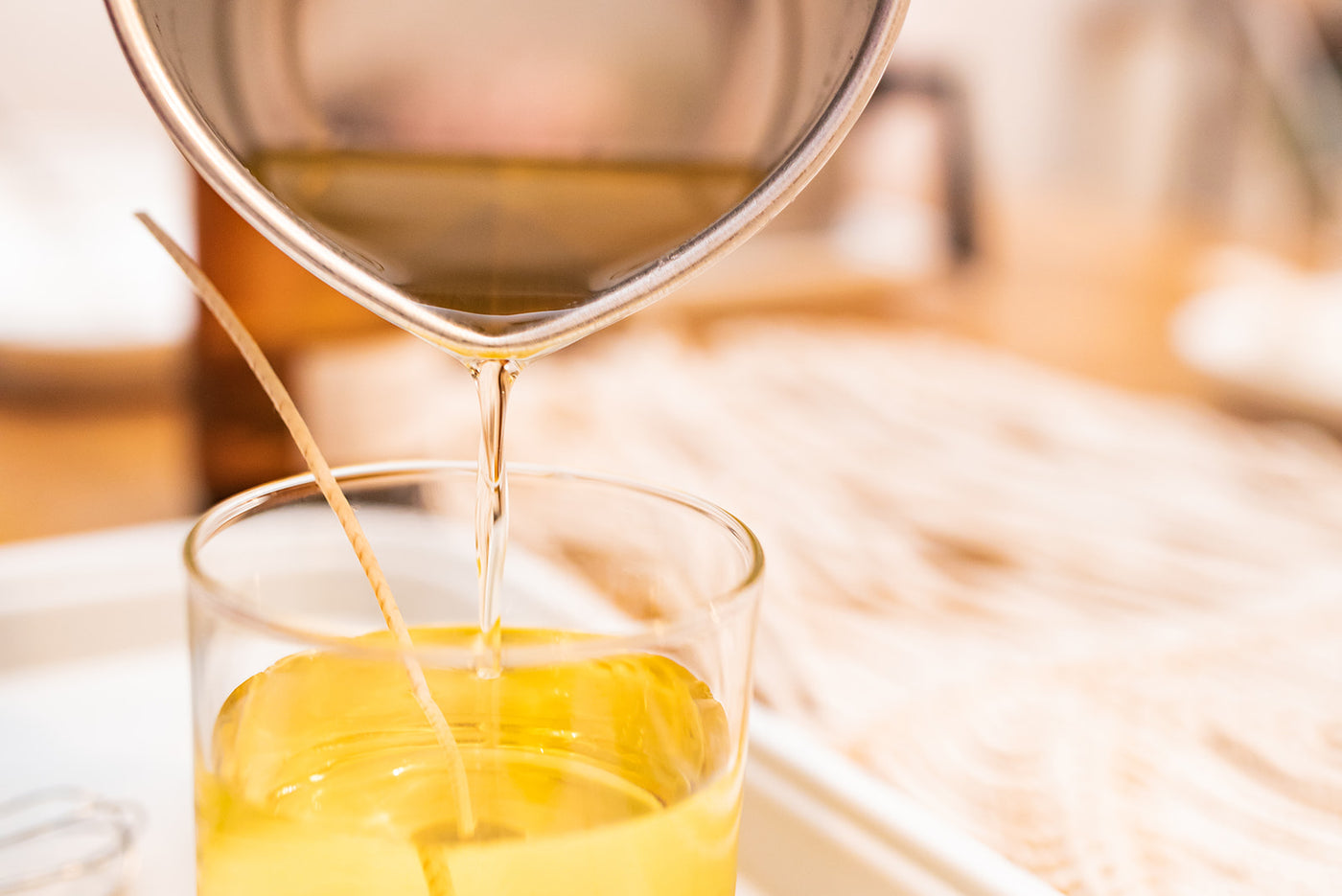 Pouring wax into candle jar.