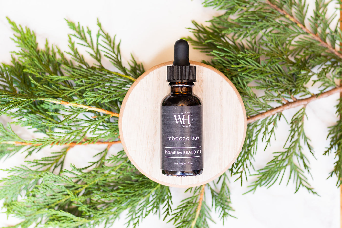 Willow Hill Soap Company Tobacco Bay premium beard oil bottle surrounded by pine 